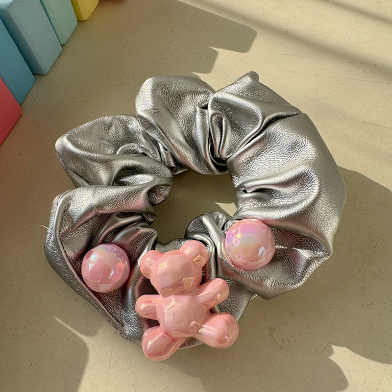 Chouchou en peluche avec un adorable ourson, un nœud et une fleur